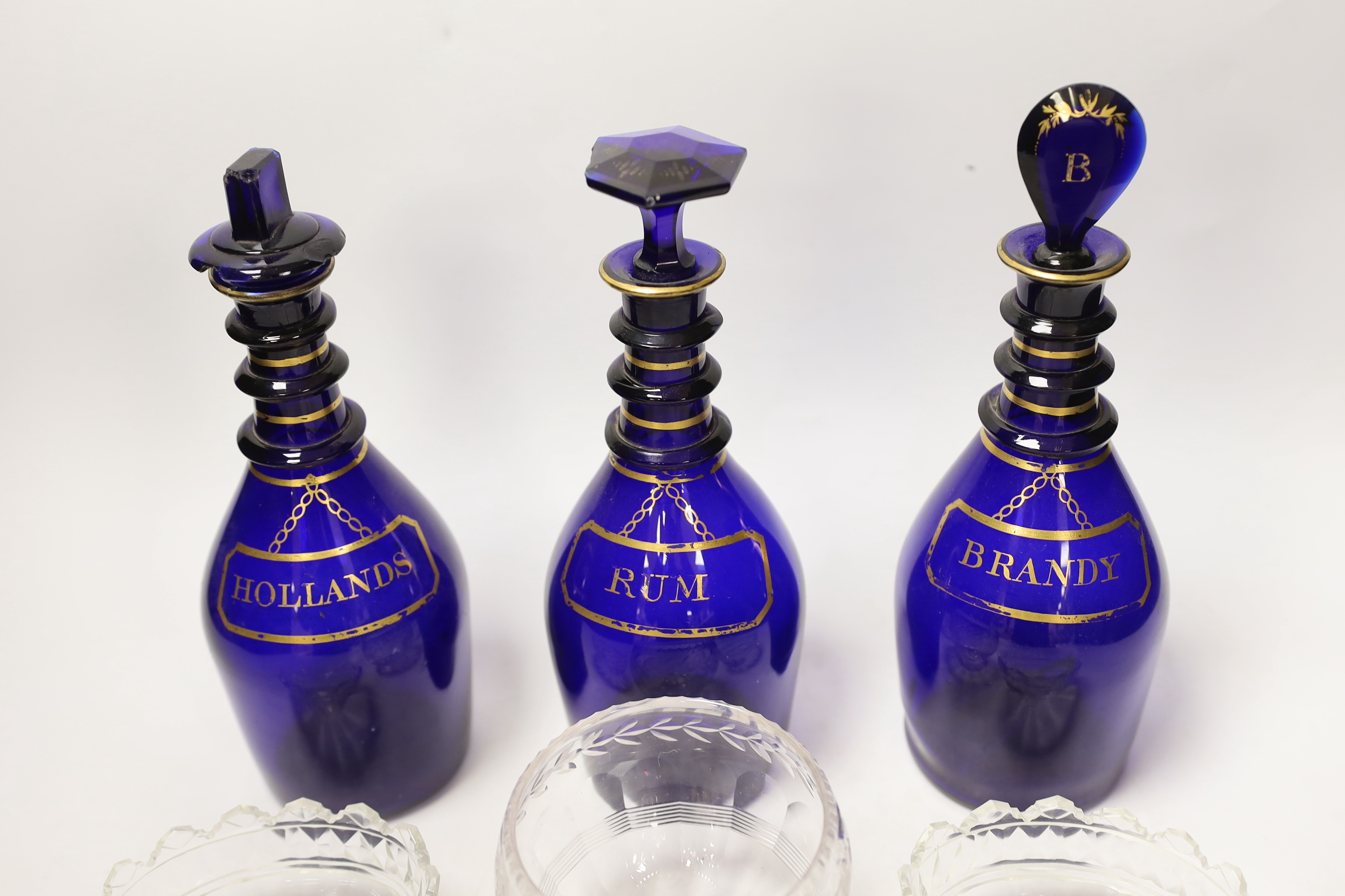 A set of three George III Bristol blue glass decanters, 25cm, and three small 19th century cut glass bowls